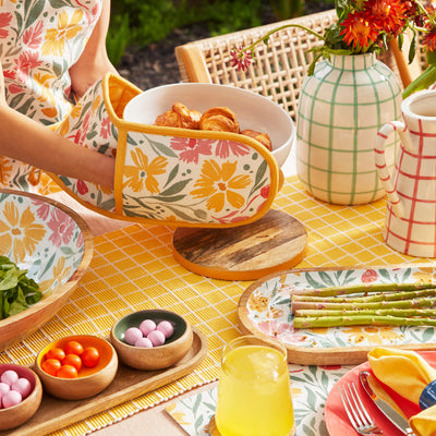 Double mitts, in floral colour, wore in the hands holding the bowl.